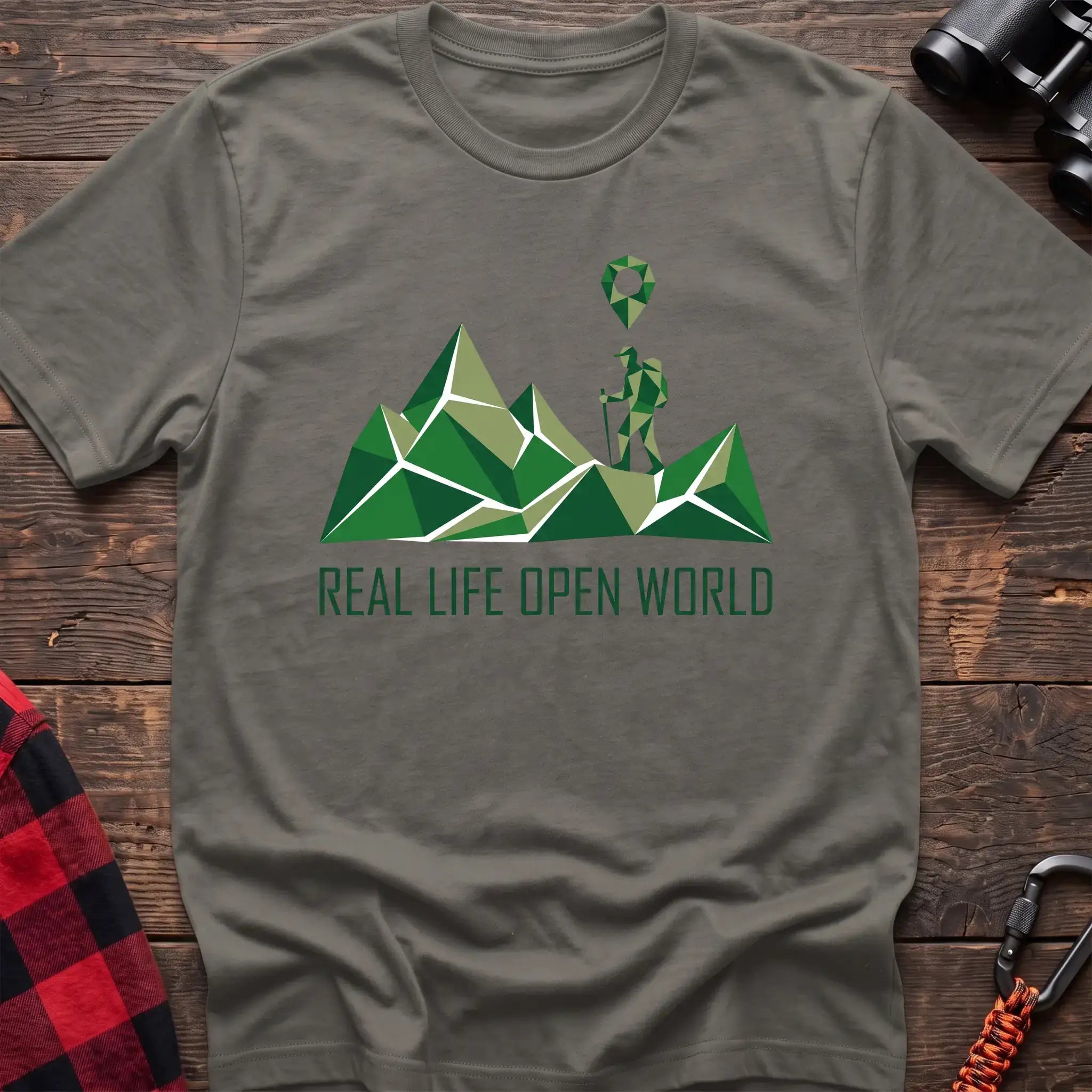 Heather military green t-shirt with geometric green mountain graphic and a hiker silhouette under a map pin, reading Real Life Open World