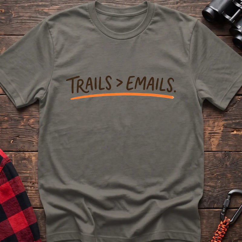 Heather military green t-shirt with brown handwritten-style text reading Trails greater than Emails and an orange underline
