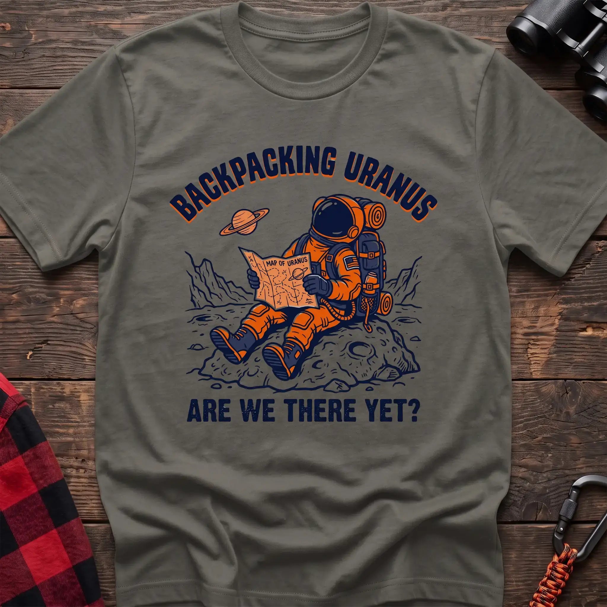 Heather military green t-shirt with astronaut sitting on a rock reading a Map of Uranus and the text Backpacking Uranus Are We There Yet