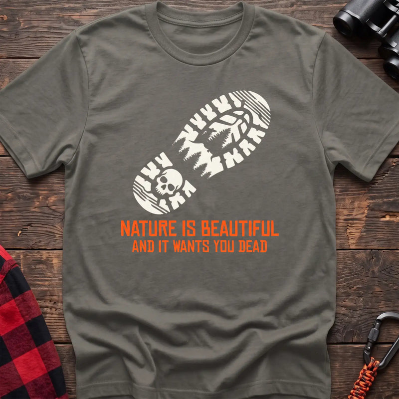 Heather military green t-shirt with white boot print graphic featuring a skull and pine trees, and orange text reading Nature Is Beautiful And It Wants You Dead