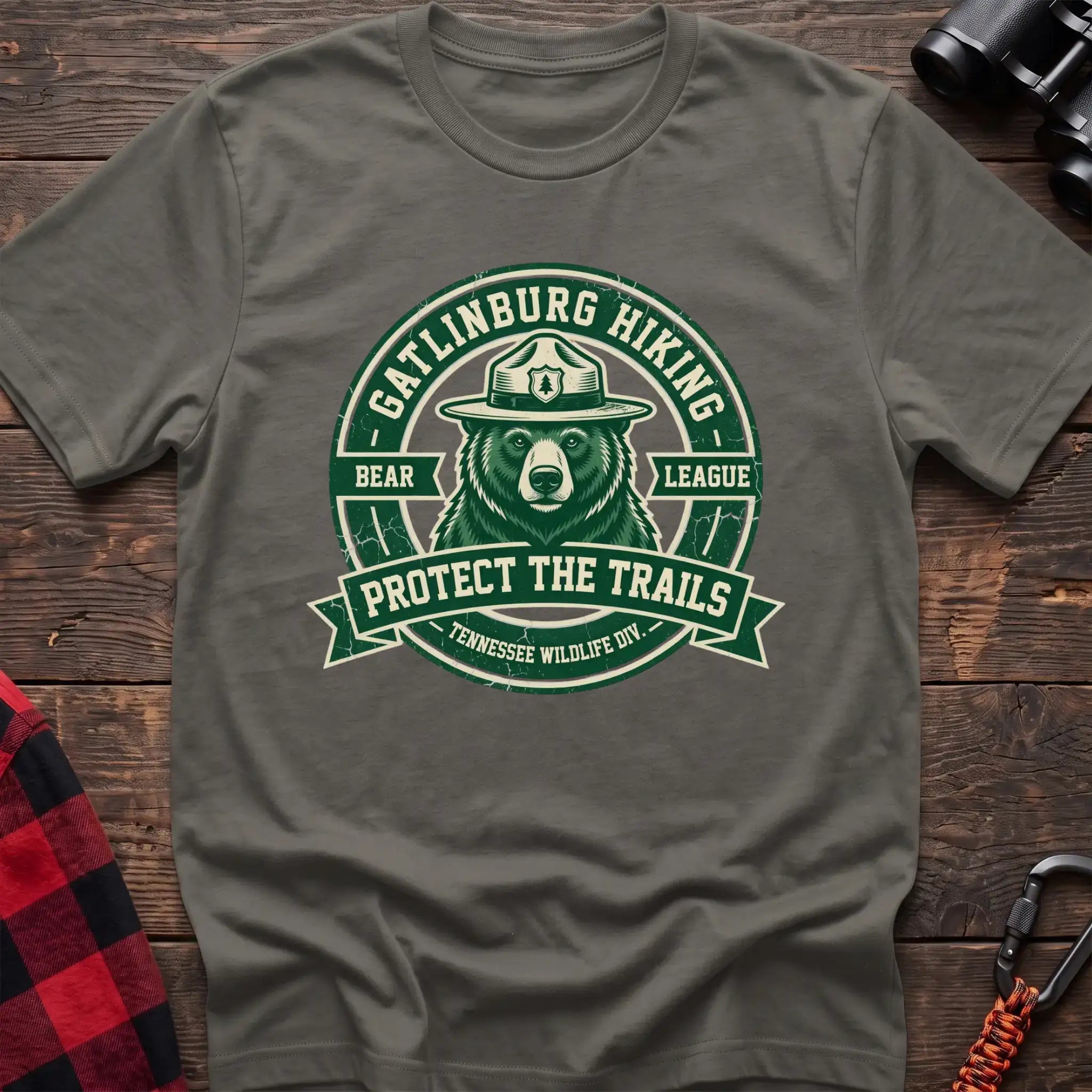 Heather military green t-shirt with circular badge of a bear in a ranger hat reading Gatlinburg Hiking Bear League Protect the Trails