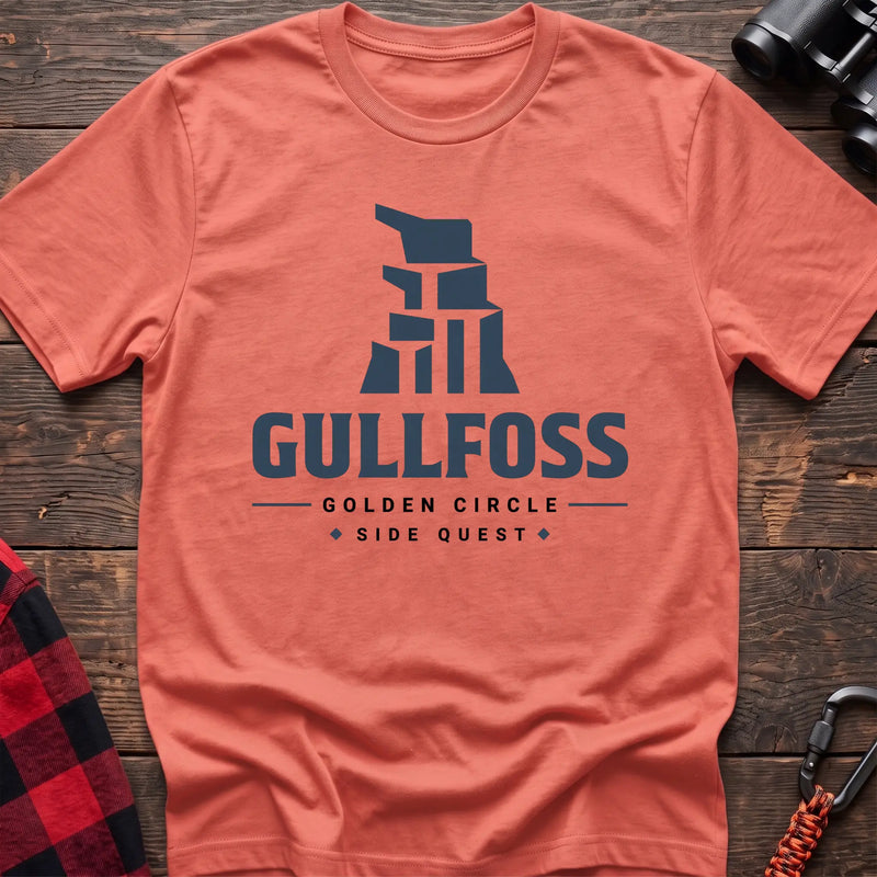 Heather orange cotton t-shirt with a stylized waterfall graphic and Gullfoss Golden Circle Side Quest text on rustic wood