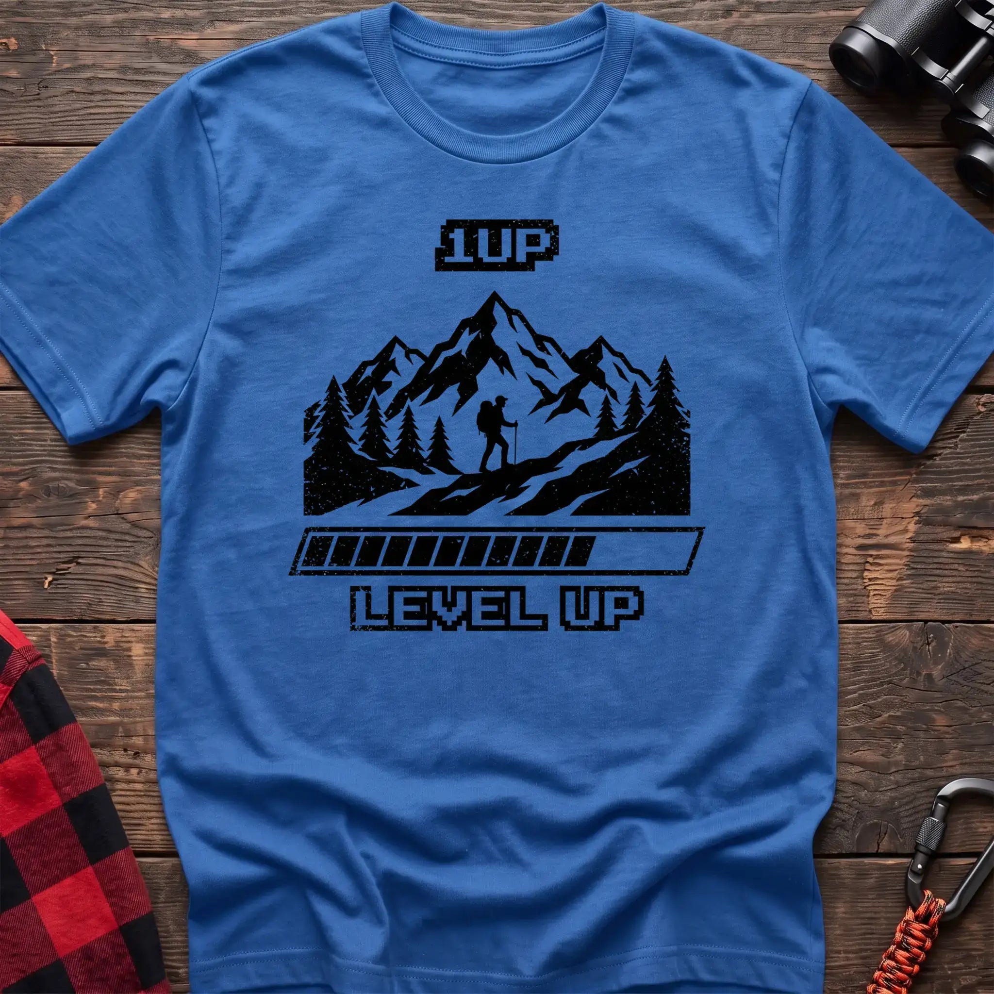 Heather royal t-shirt with black graphic of a hiker on a mountain trail under pixel-style 1UP text and a progress bar reading Level Up