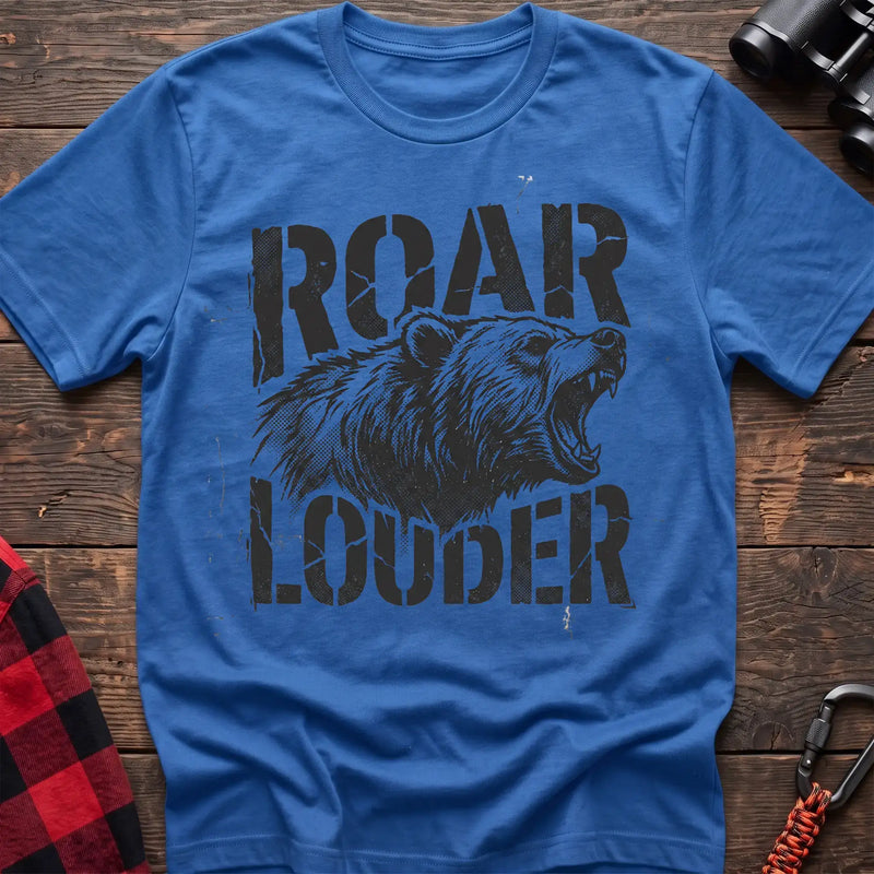 Heather royal t-shirt with a distressed black graphic of a roaring bear head between the bold text “ROAR” and “LOUDER,” laid flat on a wooden surface.