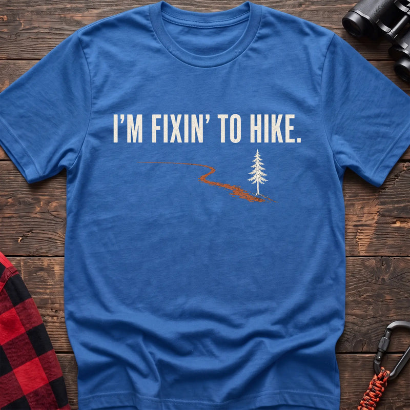 Heather royal cotton t-shirt with a trail and pine graphic and I’m Fixin’ to Hike text on rustic wood