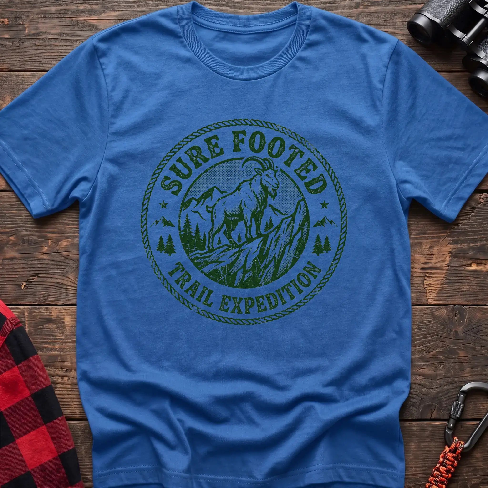 Heather royal t-shirt with circular badge graphic of a mountain goat on a rocky peak reading Sure Footed Trail Expedition