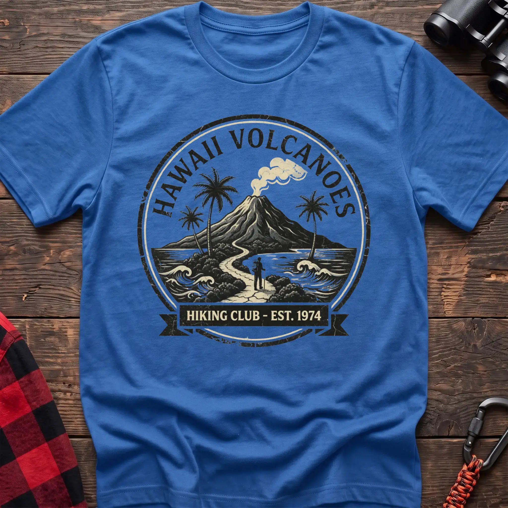 Heather royal t-shirt with circular Hawaii Volcanoes badge graphic showing a volcano, palm trees, and a hiker, reading Hiking Club Est 1974
