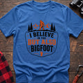 Heather royal hiking t-shirt with Bigfoot on a mountain ridge and I Believe in You But Also Bigfoot text