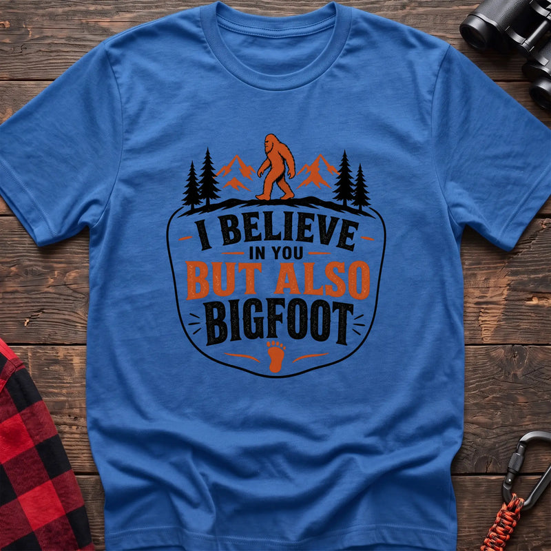 Heather royal hiking t-shirt with Bigfoot on a mountain ridge and I Believe in You But Also Bigfoot text