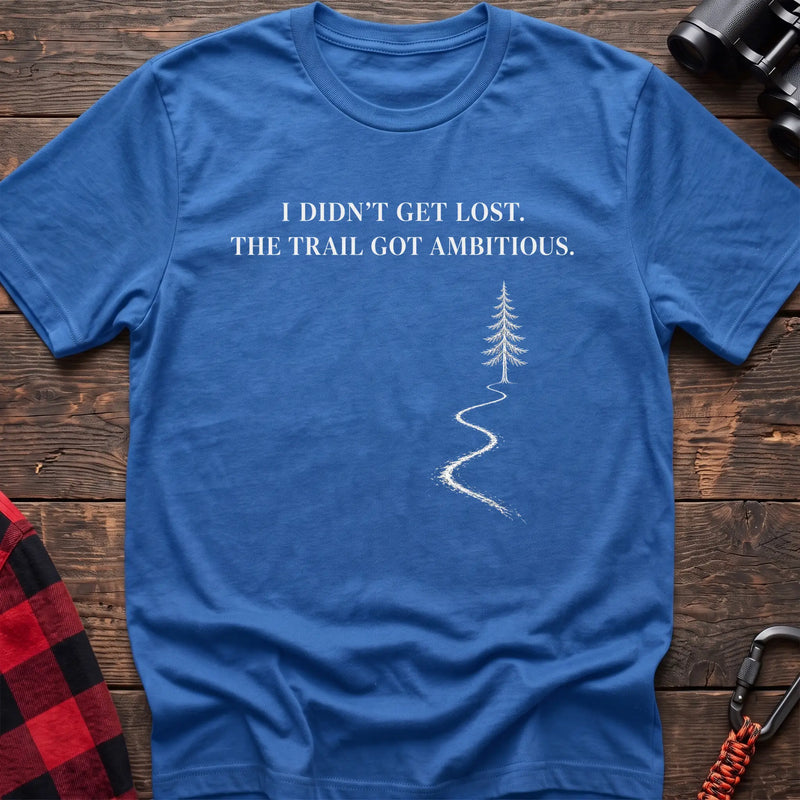 Heather royal cotton t-shirt with a winding trail graphic and I Didn’t Get Lost The Trail Got Ambitious text on rustic wood