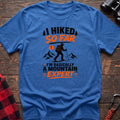Heather royal cotton t-shirt with I Hiked So Far I'm Basically a Mountain Expert graphic of a hiker with backpack and trekking pole, flat lay on rustic wood with hiking gear
