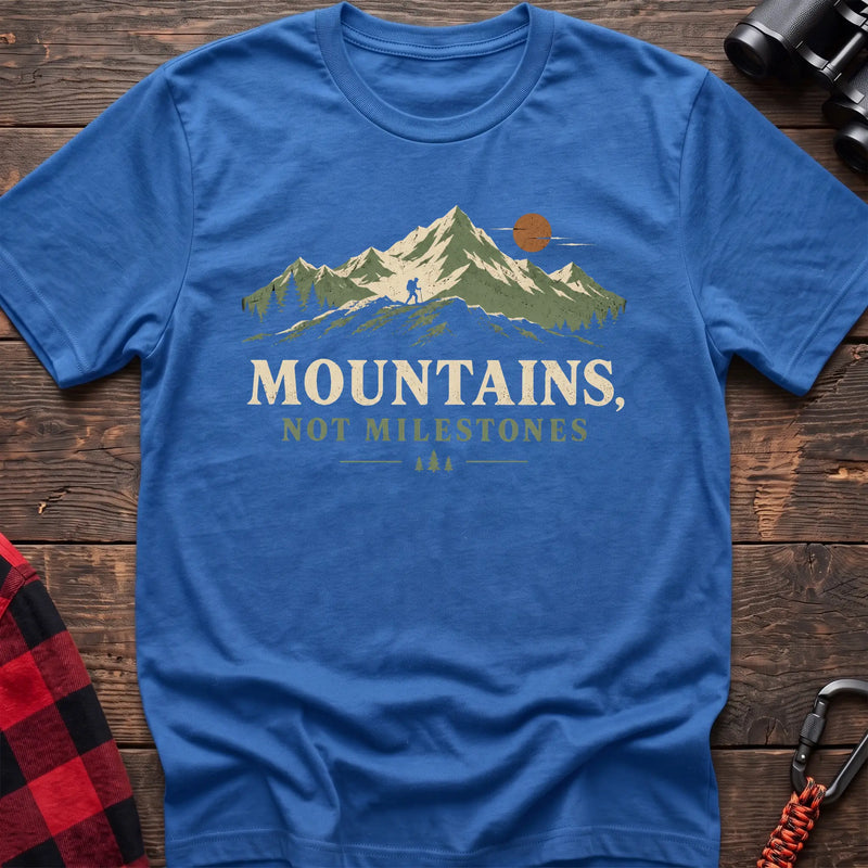 Heather royal cotton t-shirt with a hiker and mountain graphic and Mountains Not Milestones text on rustic wood
