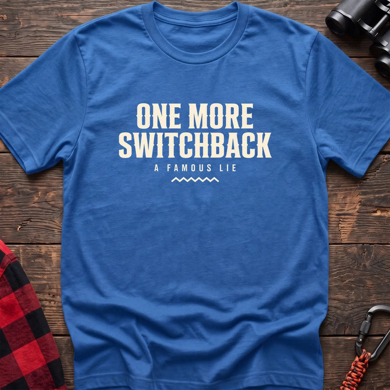 Heather royal cotton t-shirt with One More Switchback A Famous Lie text on rustic wood