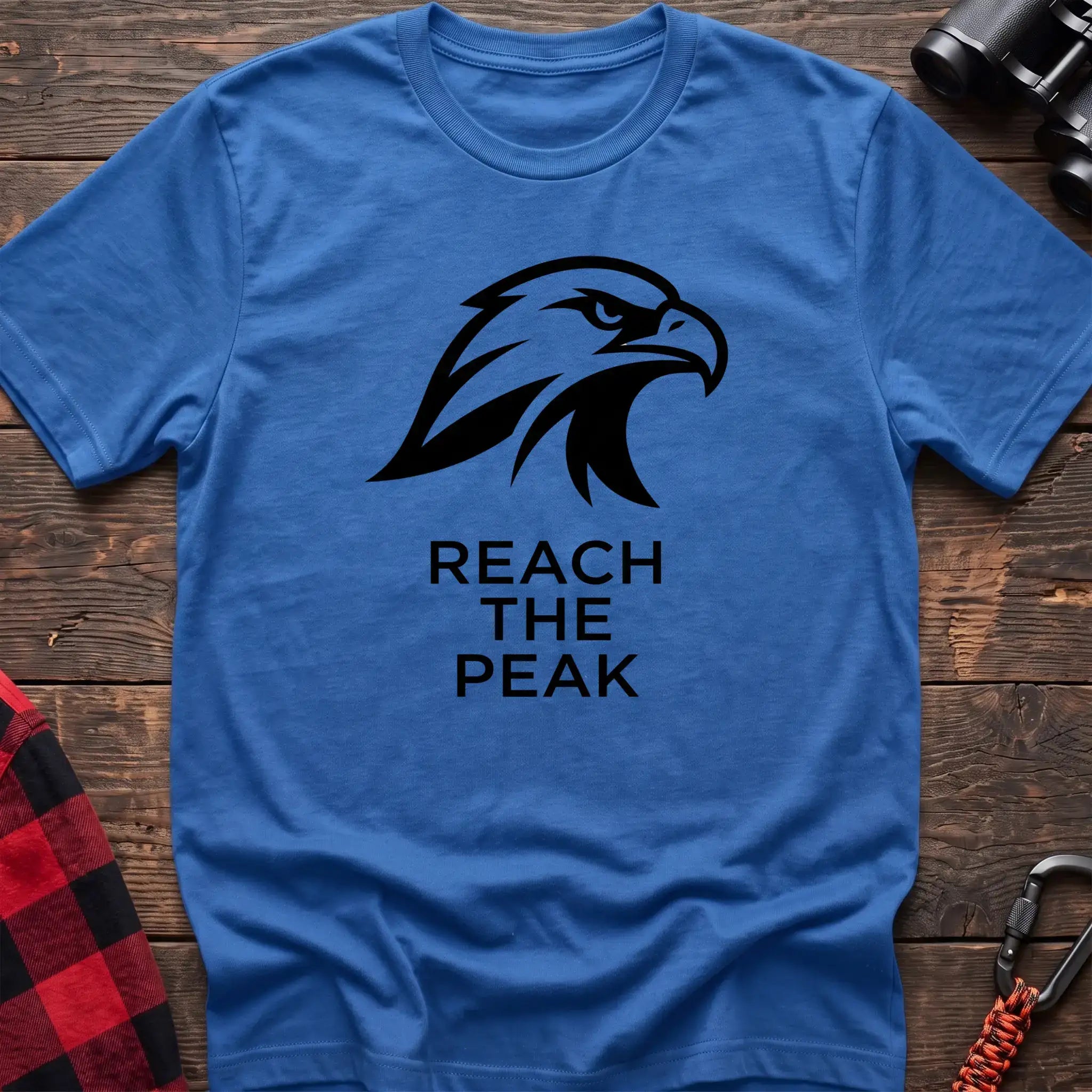Heather royal crew-neck t-shirt with a black stylized eagle head logo and the text “REACH THE PEAK” printed on the front