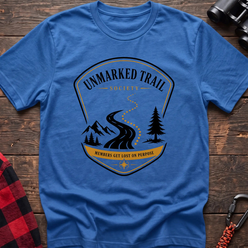 Heather royal cotton hiking t-shirt with Unmarked Trail Society badge, winding trail, mountains, pine trees, and "Members Get Lost on Purpose" text