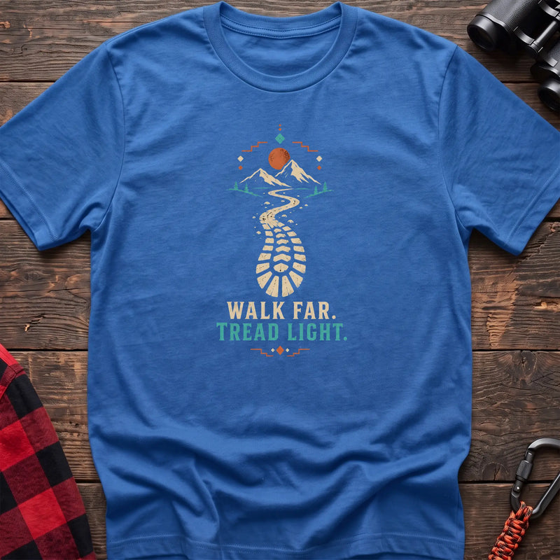 Heather royal cotton t-shirt with a bootprint trail and mountain graphic and Walk Far Tread Light text on rustic wood