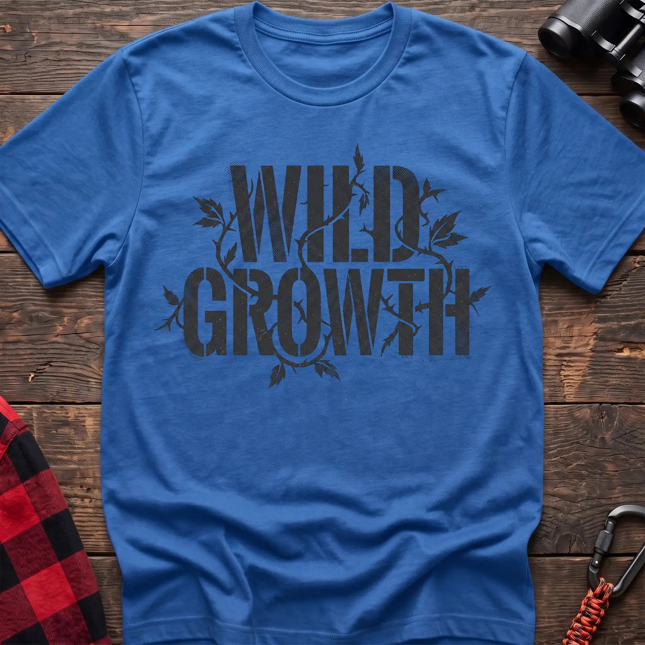 Heather royal t-shirt with dark text reading Wild Growth intertwined with thorny vines and leaves