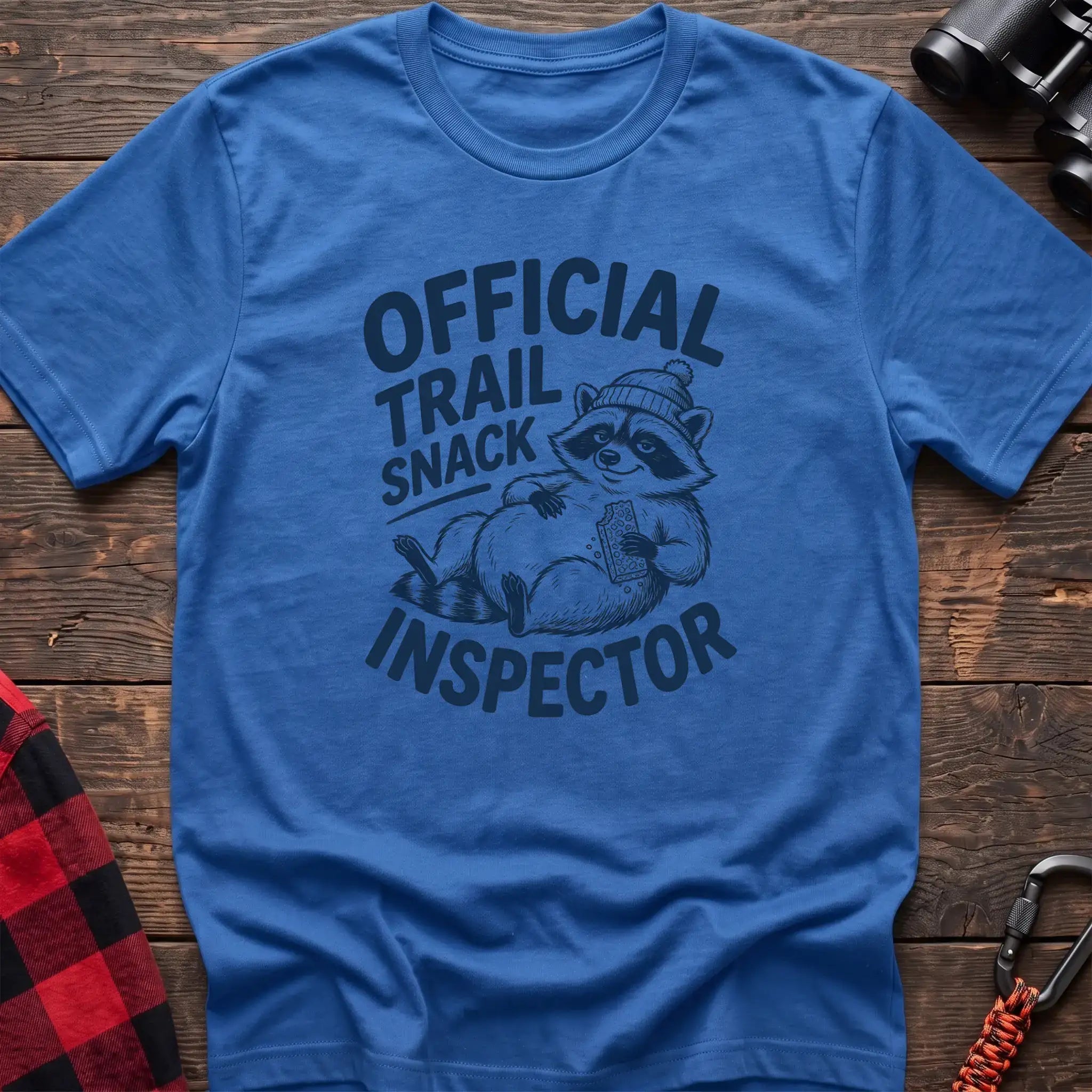 Heather royal t-shirt with cartoon raccoon holding a snack and the text Official Trail Snack Inspector