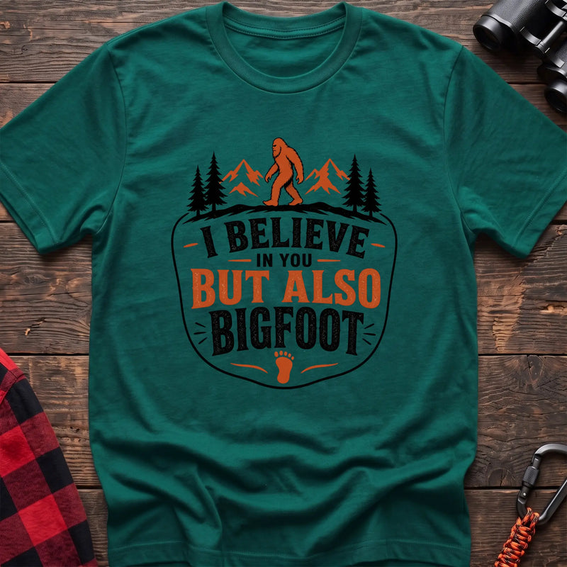 Kelly green hiking t-shirt with Bigfoot on a mountain ridge and I Believe in You But Also Bigfoot text
