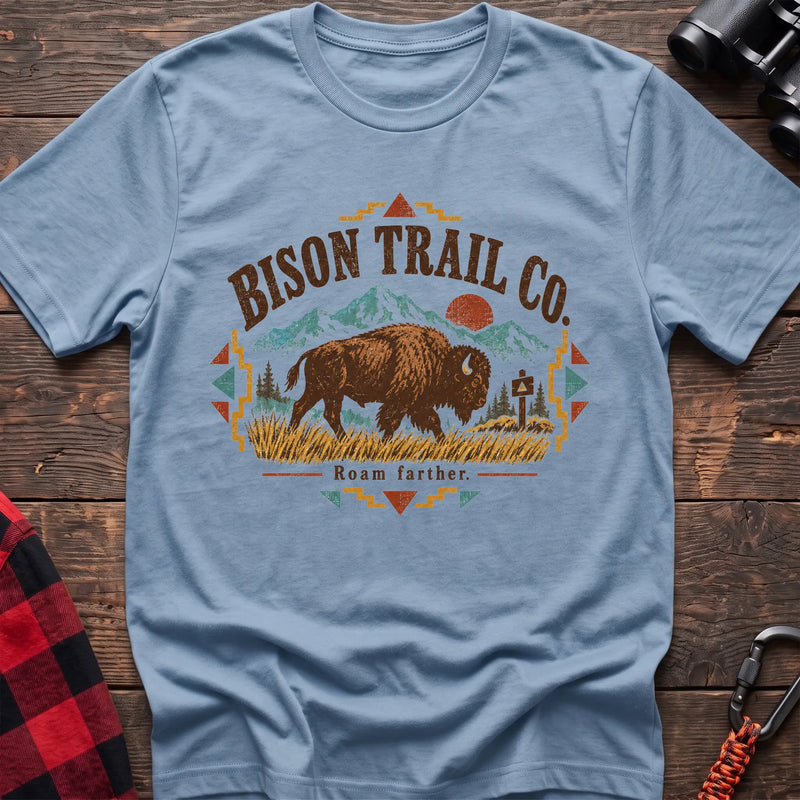 Light blue cotton t-shirt with a bison and mountain graphic and Bison Trail Co text on rustic wood