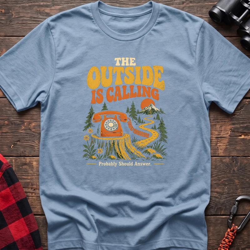 Light blue cotton t-shirt with a rotary phone on a stump graphic and The Outside Is Calling text on rustic wood