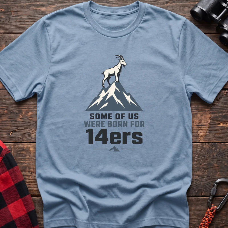 Light blue hiking t-shirt with a mountain goat on a peak and the text “Some of Us Were Born for 14ers”