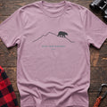 Light pink hiking t-shirt with a line-art mountain, walking bear, and the text “Keep Your Distance”
