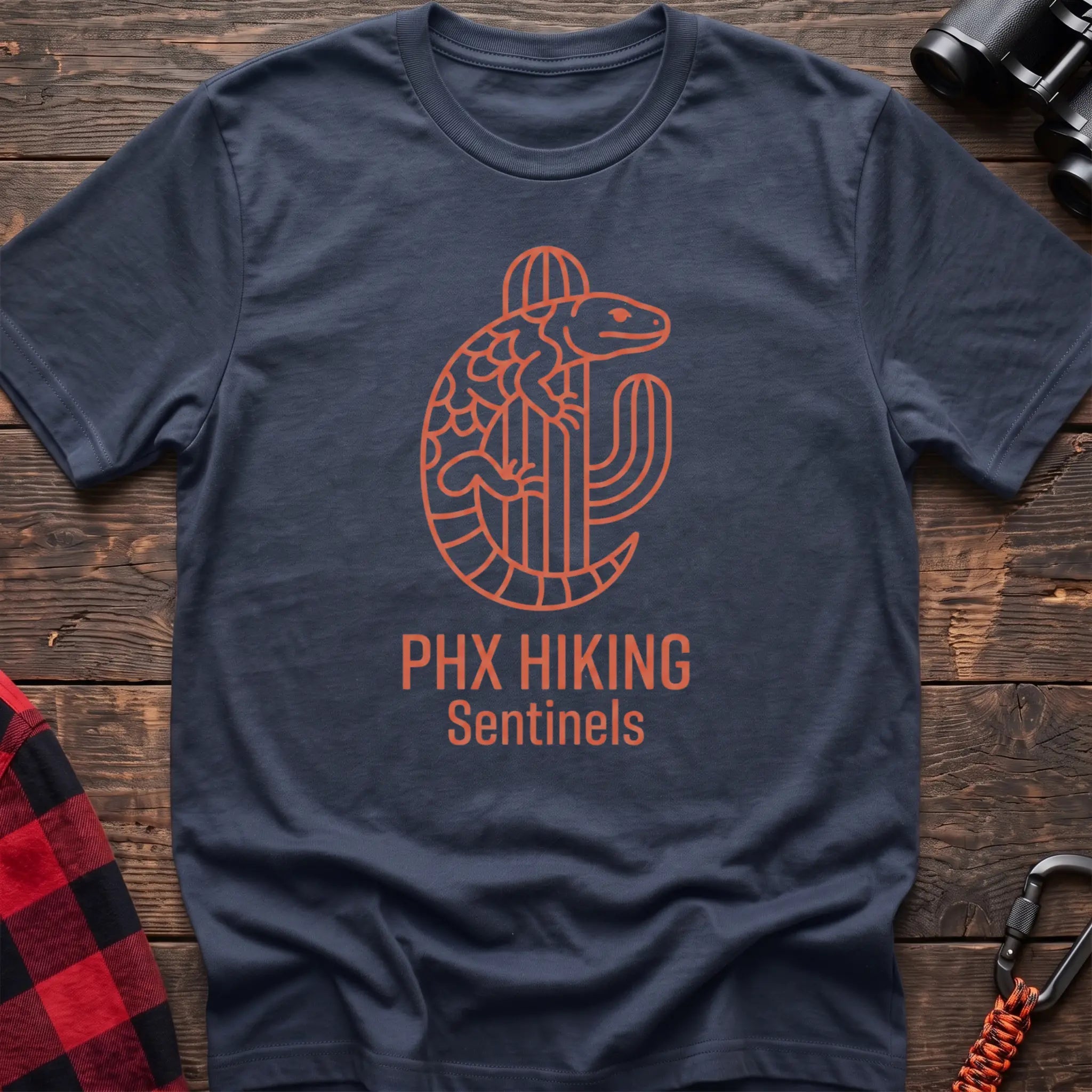Navy t-shirt with orange line-art Gila monster wrapped around a saguaro cactus and the text “PHX HIKING Sentinels”