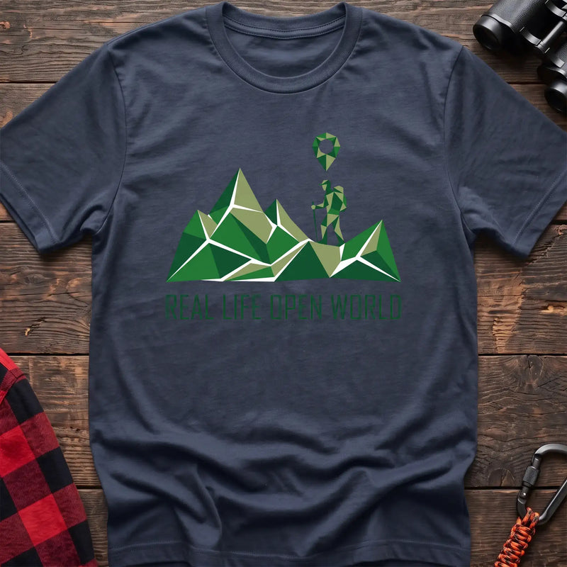 Navy t-shirt with geometric green mountain graphic and a hiker silhouette under a map pin, reading Real Life Open World