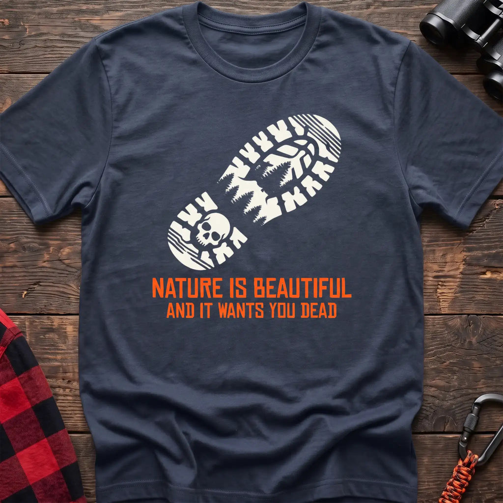 Navy t-shirt with white boot print graphic featuring a skull and pine trees, and orange text reading Nature Is Beautiful And It Wants You Dead