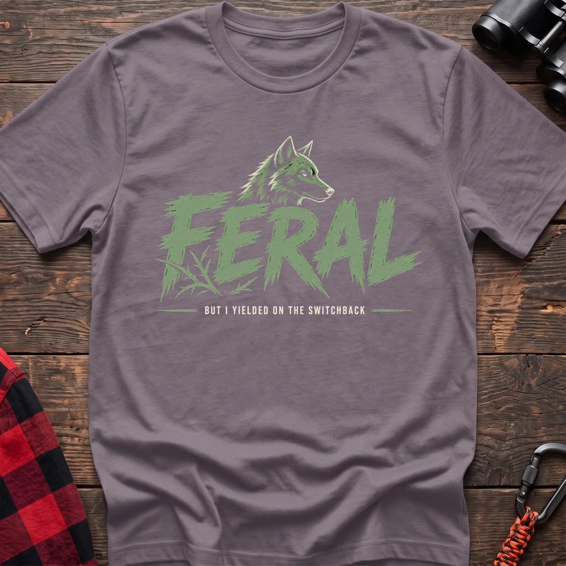 Paragon cotton t-shirt with a wolf graphic and Feral But I Yielded on the Switchback text on rustic wood