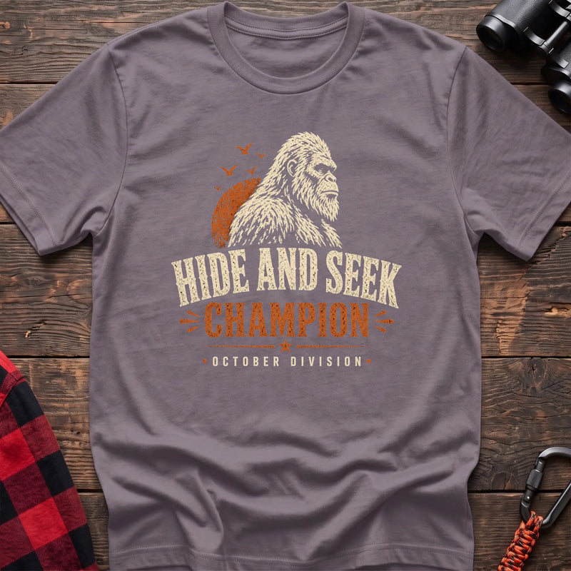 Paragon cotton t-shirt with a Bigfoot graphic and Hide and Seek Champion October Division text on rustic wood