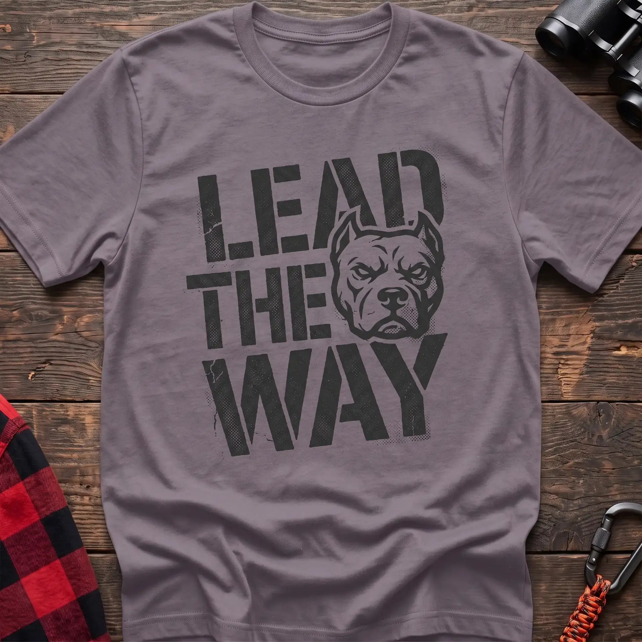 Paragon t-shirt with a distressed graphic of a stern pit bull head integrated into the bold text “LEAD THE WAY,” laid flat on a wooden surface.
