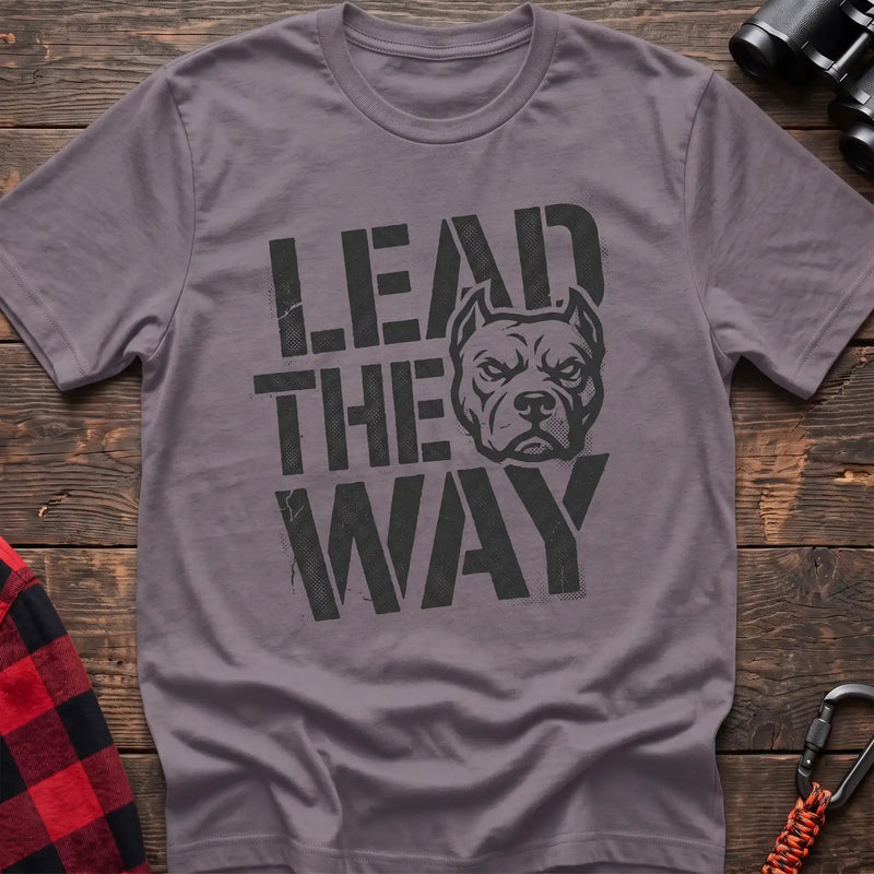 Paragon t-shirt with a distressed graphic of a stern pit bull head integrated into the bold text “LEAD THE WAY,” laid flat on a wooden surface.