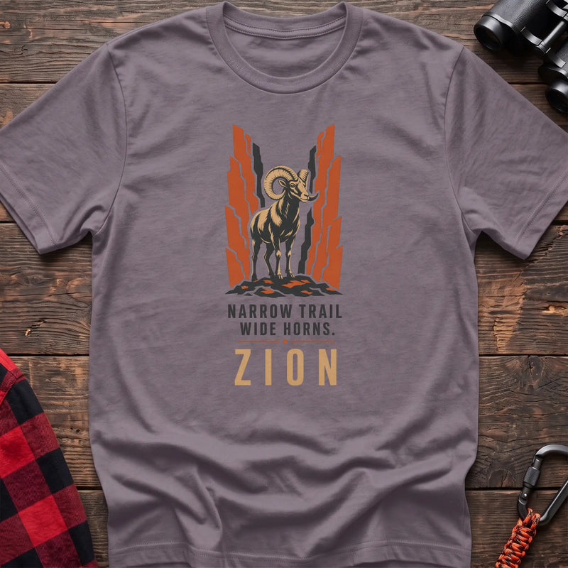 Paragon cotton t-shirt with a bighorn sheep graphic and Narrow Trail Wide Horns Zion text on rustic wood