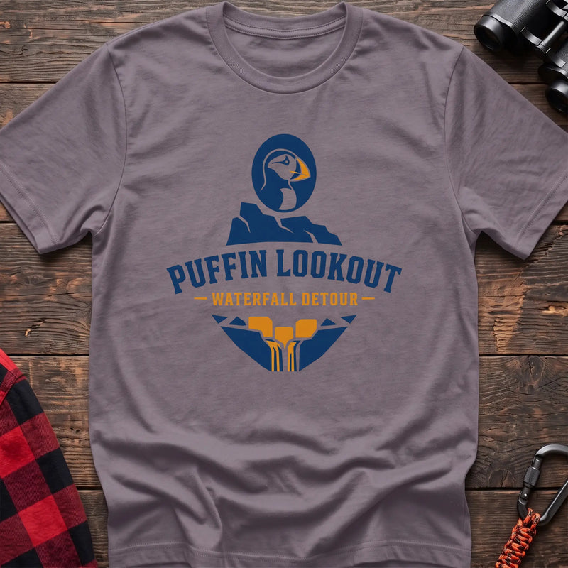 Paragon cotton t-shirt with a puffin and waterfall graphic and Puffin Lookout Waterfall Detour text on rustic wood