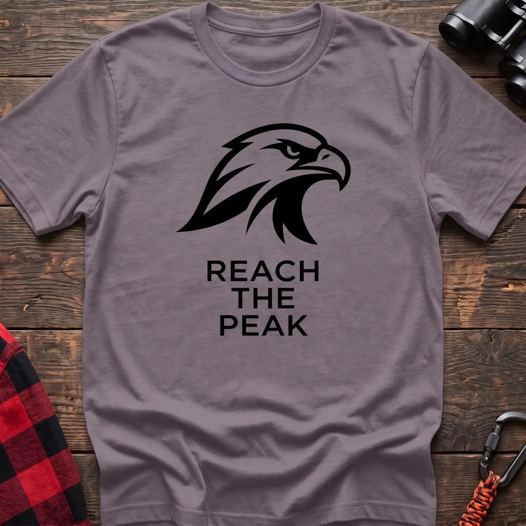 Paragon crew-neck t-shirt with a black stylized eagle head logo and the text “REACH THE PEAK” printed on the front