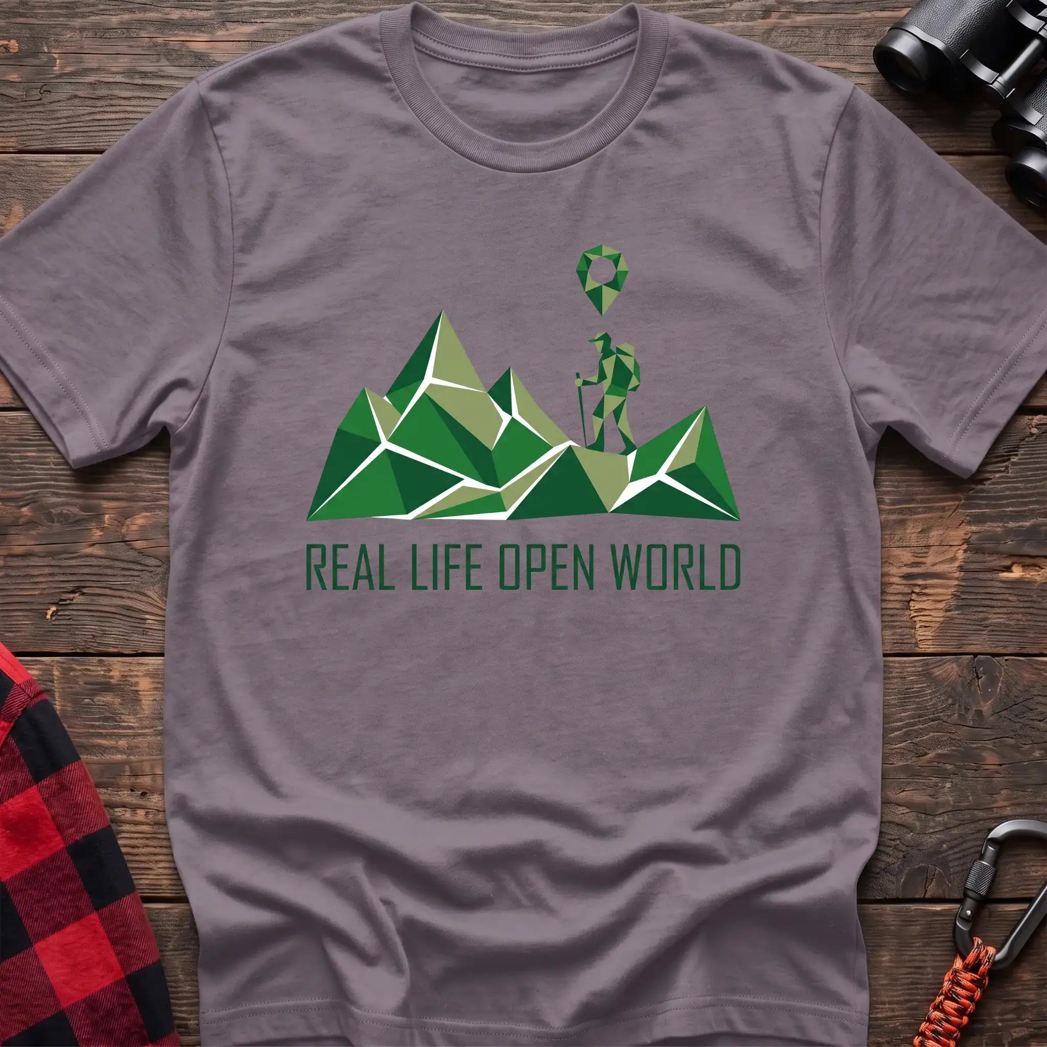 Paragon t-shirt with geometric green mountain graphic and a hiker silhouette under a map pin, reading Real Life Open World