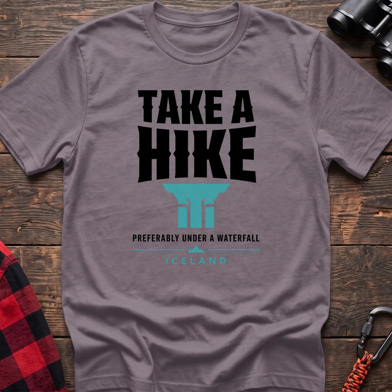 Paragon cotton t-shirt with a waterfall graphic and Take a Hike Preferably Under a Waterfall Iceland text on rustic wood