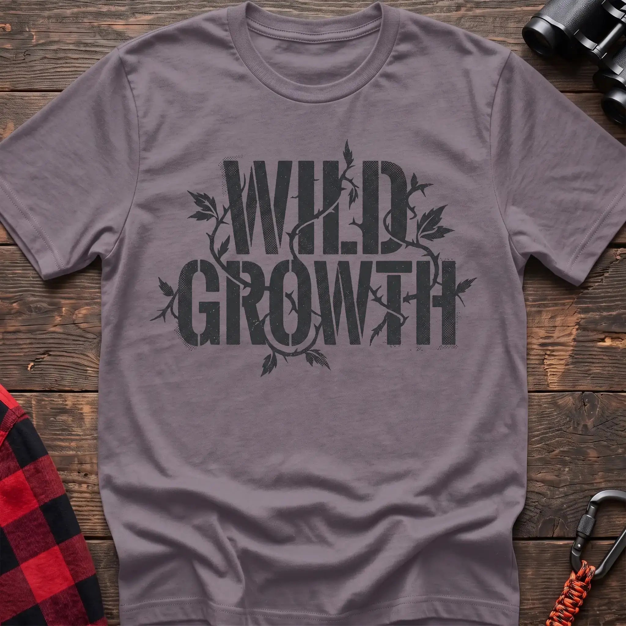 Paragon t-shirt with dark text reading Wild Growth intertwined with thorny vines and leaves