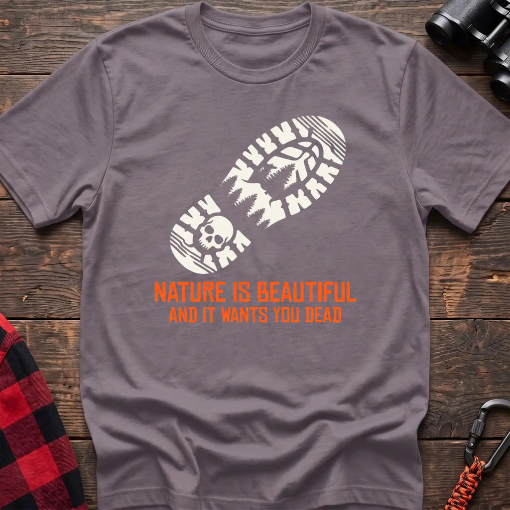 Paragon t-shirt with white boot print graphic featuring a skull and pine trees, and orange text reading Nature Is Beautiful And It Wants You Dead