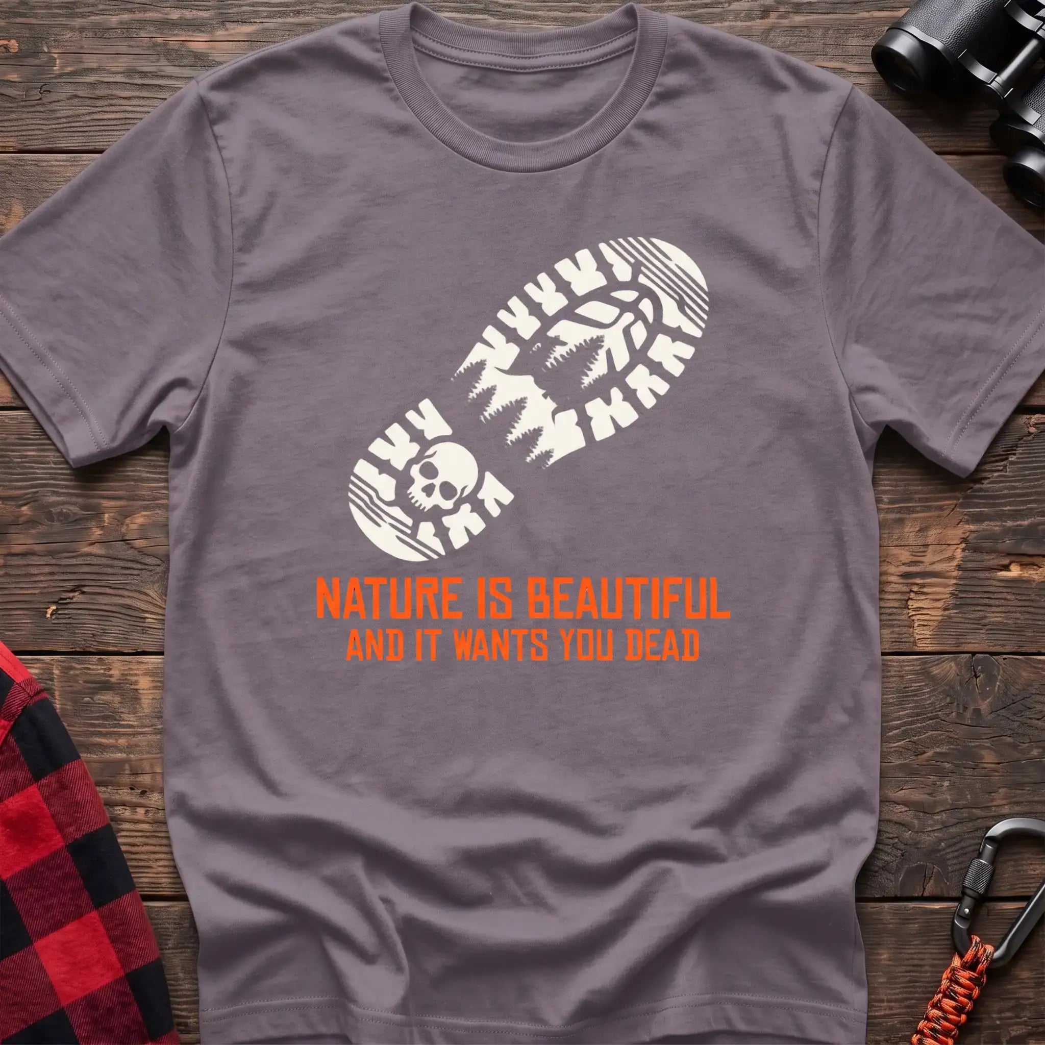 Paragon t-shirt with white boot print graphic featuring a skull and pine trees, and orange text reading Nature Is Beautiful And It Wants You Dead