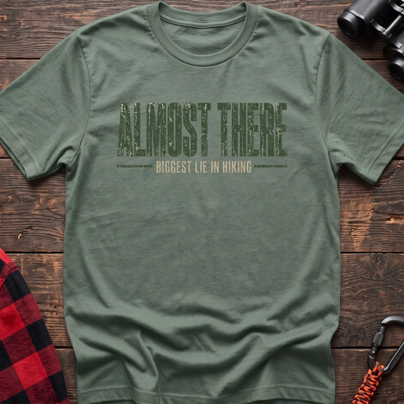 Sage cotton t-shirt with Almost There Biggest Lie in Hiking text on rustic wood