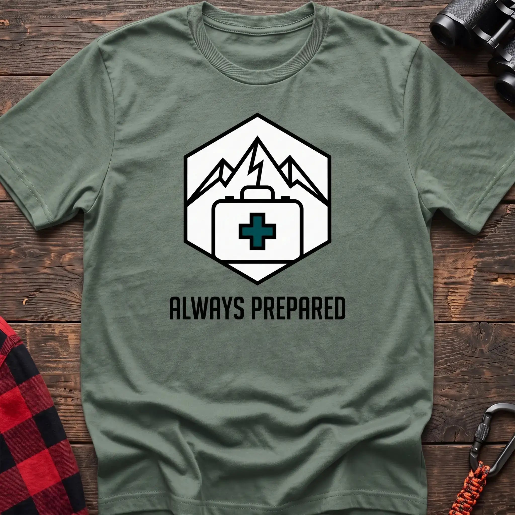 Sage t-shirt with hexagonal badge graphic of mountains and a first aid kit, reading Always Prepared