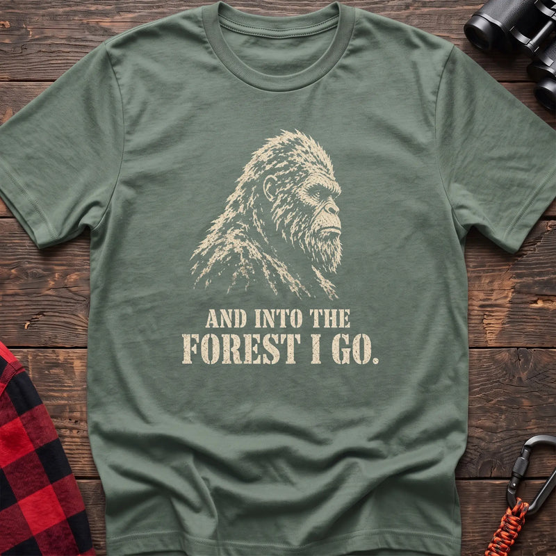 Sage cotton t-shirt with a Bigfoot graphic and And Into the Forest I Go text on rustic wood