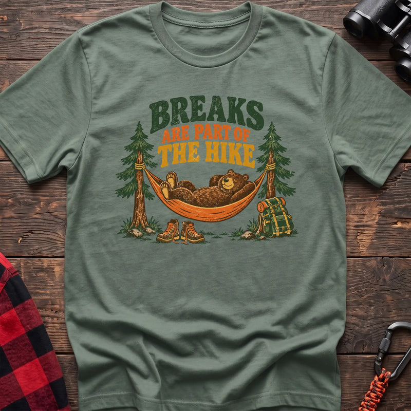 Sage cotton t-shirt with a bear in a hammock graphic and Breaks Are Part of the Hike text on rustic wood