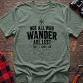 Sage cotton hiking t-shirt with compass, "Not all who wander are lost but I sure am" quote, and dotted wandering path graphic