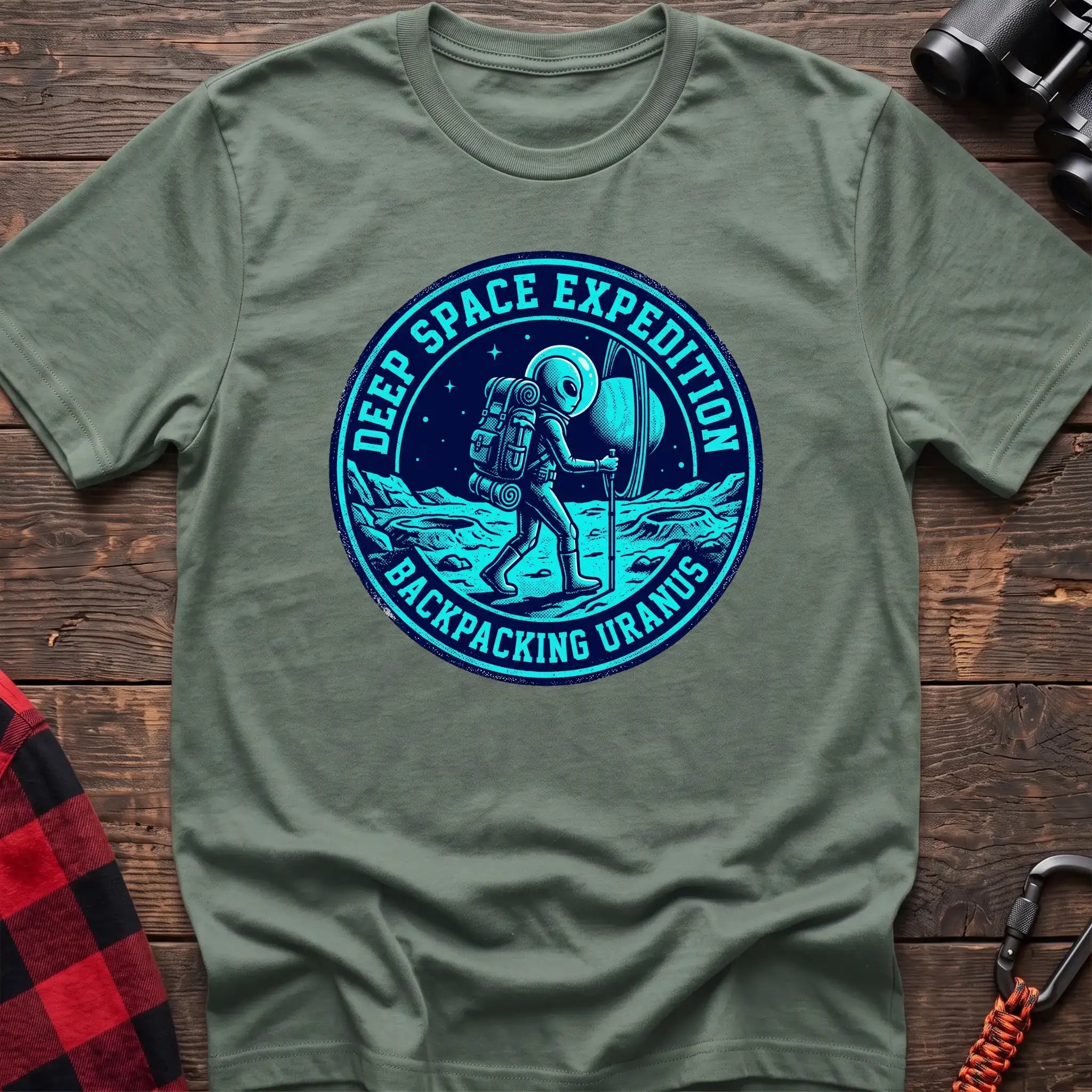 Sage t-shirt with circular badge graphic of an alien backpacking on Uranus, reading Deep Space Expedition Backpacking Uranus