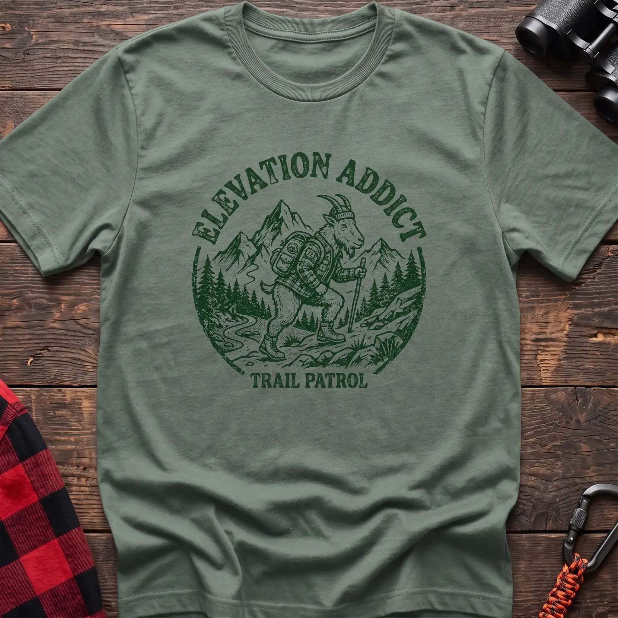 Sage t-shirt with circular graphic of a hiking mountain goat and the text Elevation Addict Trail Patrol