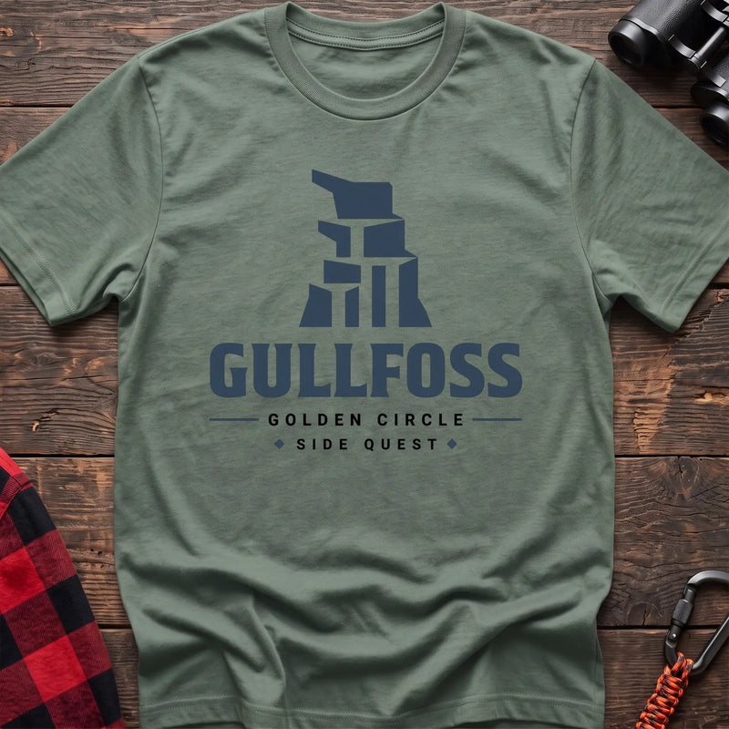 Sage cotton t-shirt with a stylized waterfall graphic and Gullfoss Golden Circle Side Quest text on rustic wood